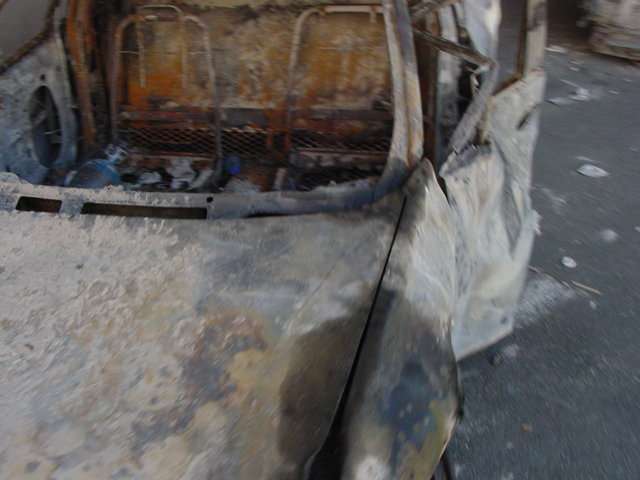Figure 50. (9/13/01) NYPD Car 2723 on FDR Drive showing missing driver door handle and unusual unburned circular area on left rear door, demonstrating interferometric side-lobe radiation pattern